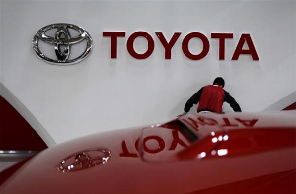 An employee works under a Toyota Motor Corp logo at the company's showroom in Tokyo, Japan February 5, 2016. REUTERS/Toru Hanai/File Photo - RTSKYTG